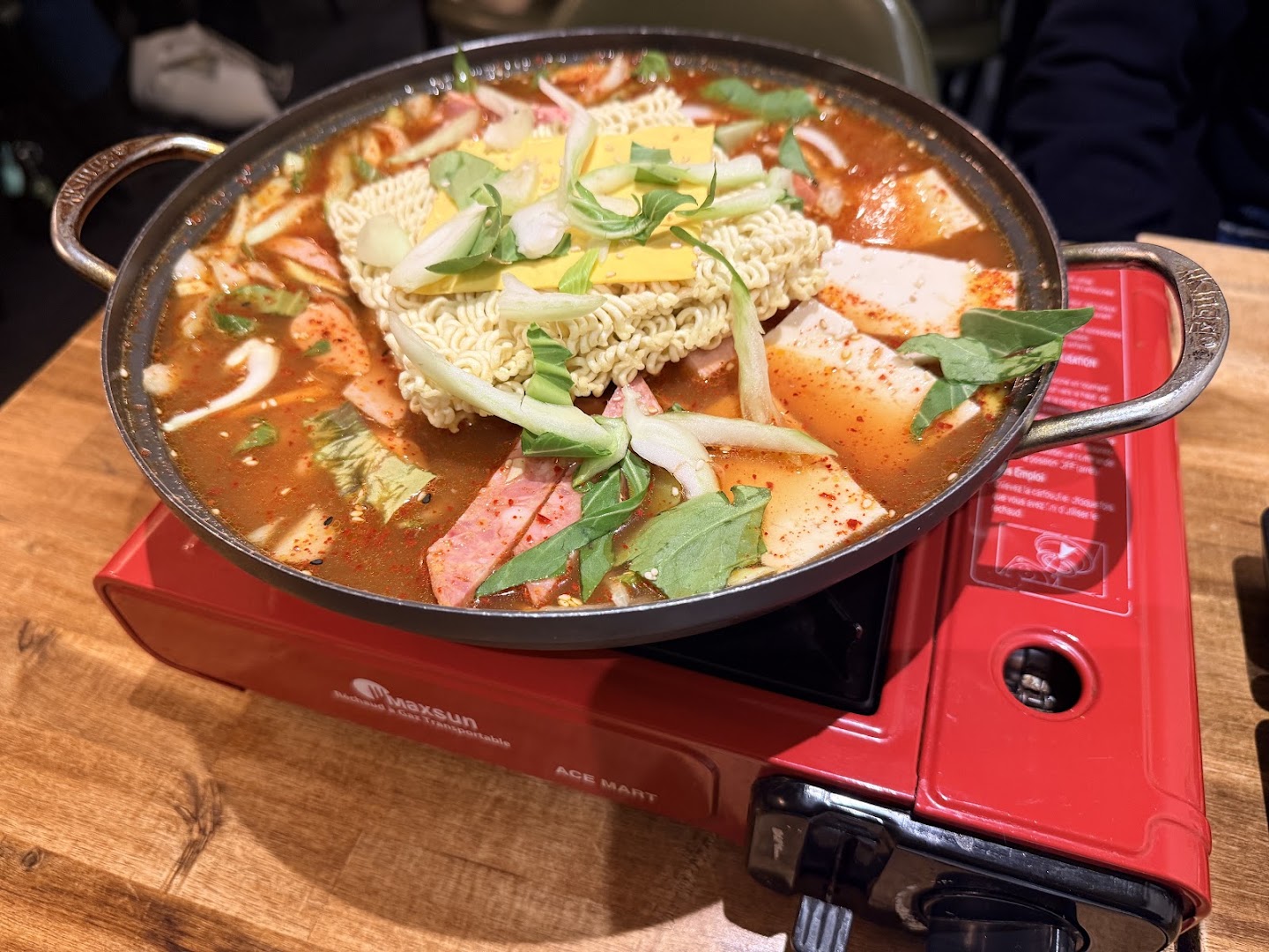 Un ragoût coréen servi sur un réchaud rouge chez Busan